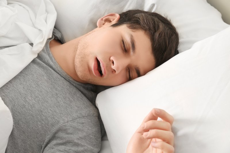 Young man with sleep apnea lying in bed