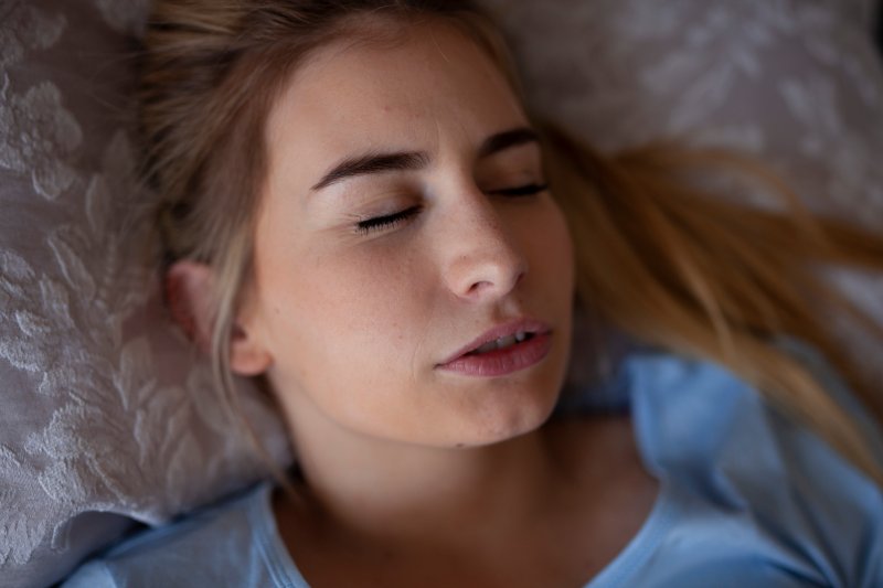 Woman with jaw pain and sleep apnea in bed