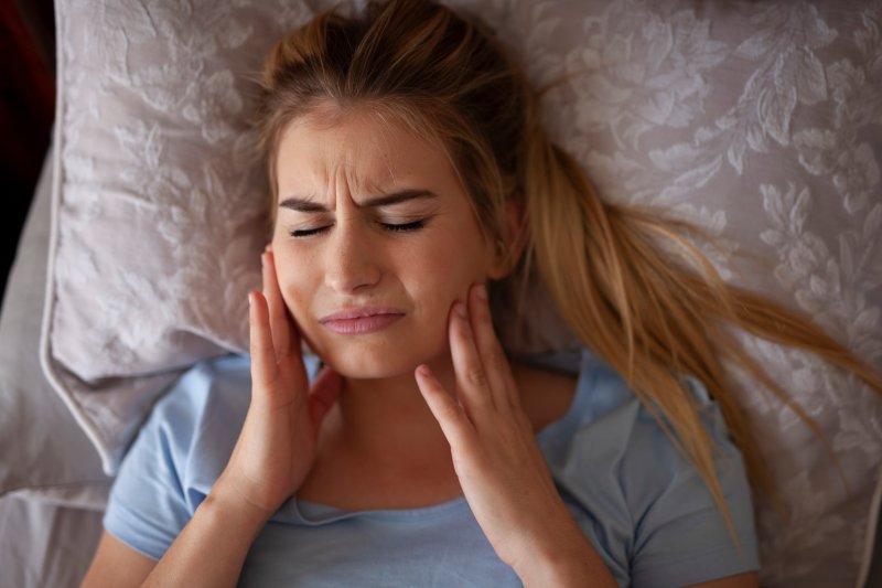 woman with jaw pain after sleeping.